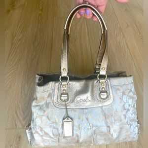 Medium sized Coach purse. Lt tan & gold w/ purple interior. All zippers work.